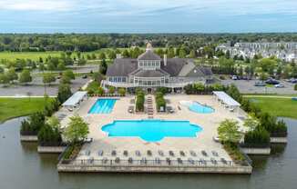 an aerial view of a large pool with a building in the background