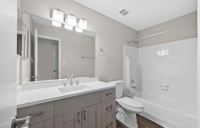A white bathroom with a sink, toilet, and bathtub.
