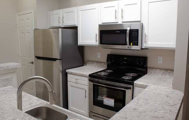 Enclave at Wolfchase Apartments in Cordova Tennessee photo of a kitchen with white cabinets and stainless steel appliances