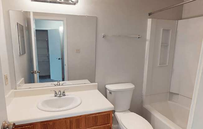 A white sink with a wooden cabinet below it.