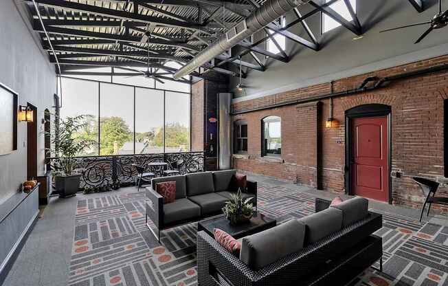 a living room with couches and a red door at The Knights @ 506 Delaware Apartments, Buffalo, NY