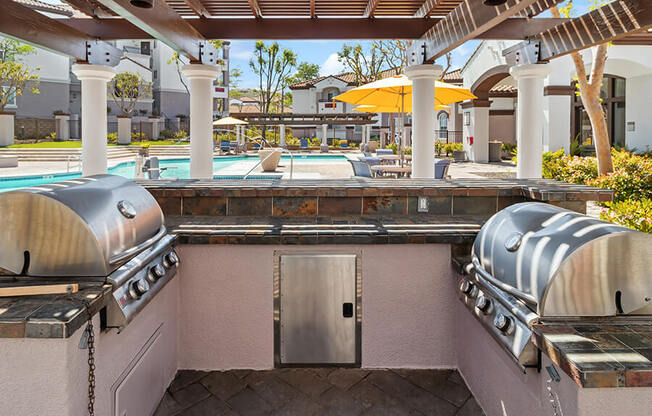 Outdoor BBQ Area with Canopy & View of Pool at Reserve at Rancho Apartments located in Moreno Valley, CA.