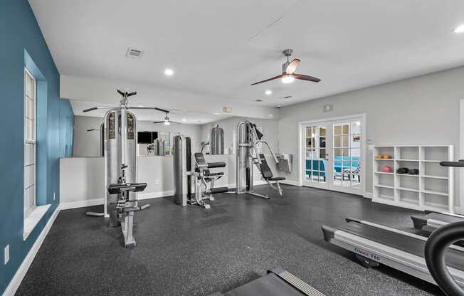 A spacious home gym with a variety of equipment including a treadmill, weights, and a bench press.