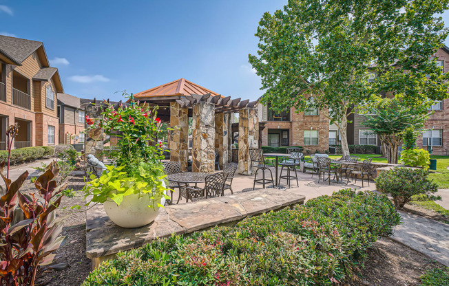 our apartments offer a courtyard with tables and chairs and plants at River Pointe, Texas