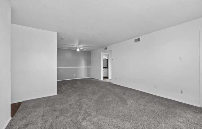 an empty living room with carpet and white walls