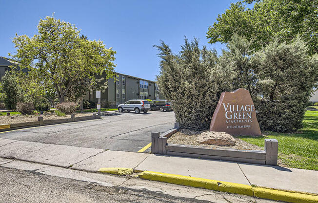 a sign for the village green on the side of a street