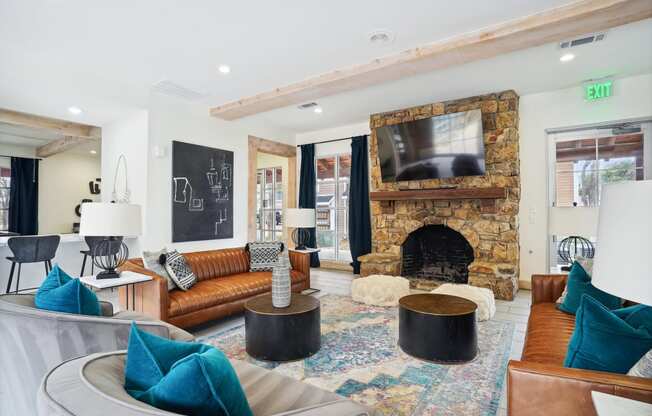 the living room has a large stone fireplace and a tv above it
