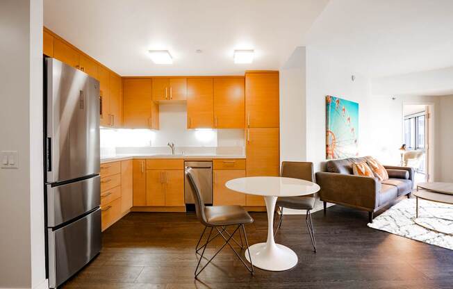 A kitchen with orange cabinets and a white table.