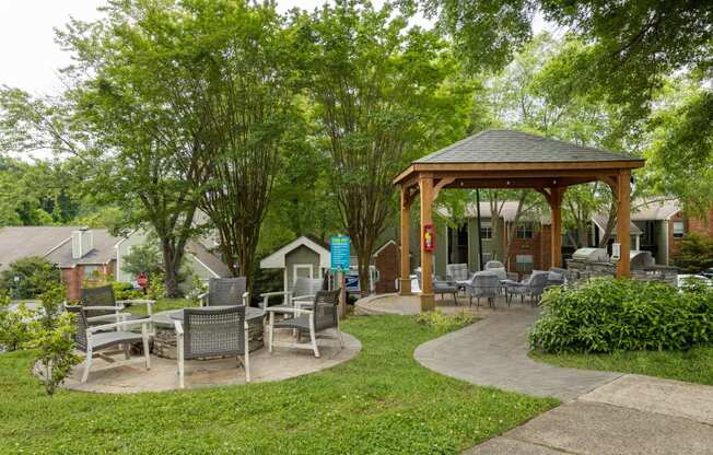 a pavilion with tables and chairs in a garden