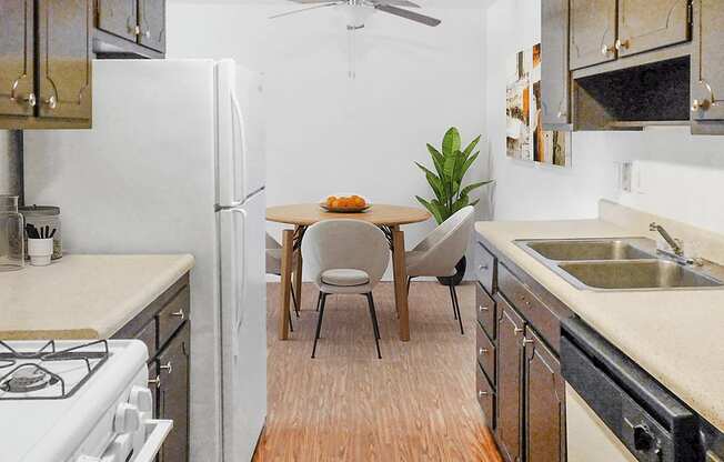 A kitchen with a table and chairs in the middle.