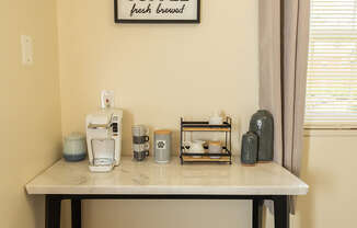 A coffee table with a coffee sign on the wall behind it.