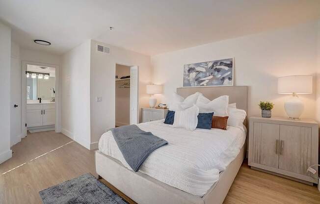 A bedroom with a large bed and a painting above it.