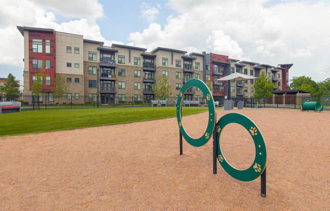 a playground with a large infinity sign in front of an apartment building