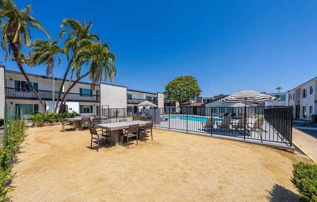 A sunny day at the poolside with a table and chairs set up.