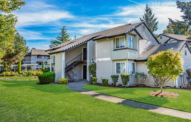 the front of a house with a yard and a sidewalk