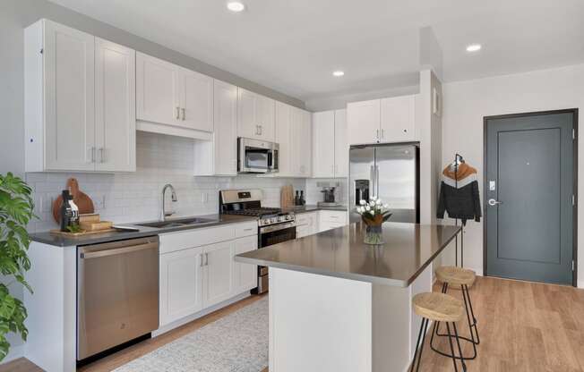 a kitchen with white cabinets and stainless steel appliances