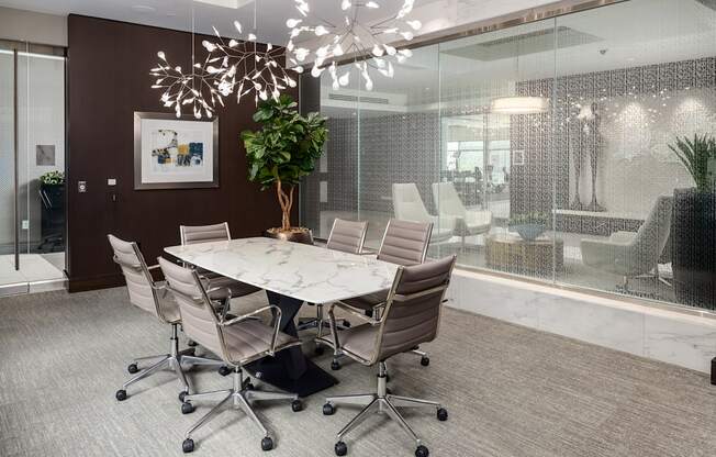 A conference room with a white table and chairs.