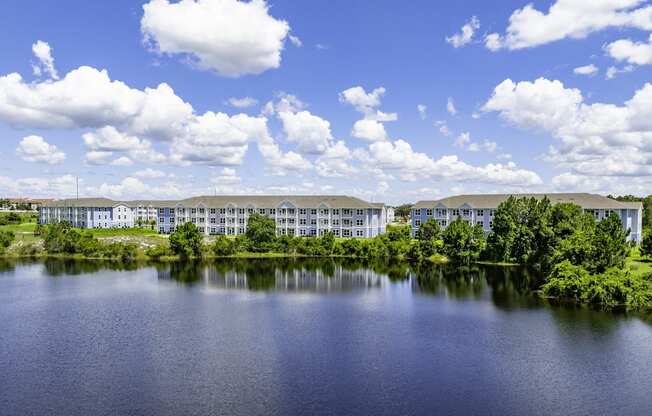 an apartment building overlooking a lake on a sunny day