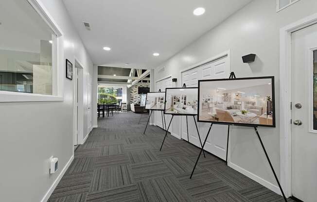 A room with two paintings on easels and a carpeted floor.