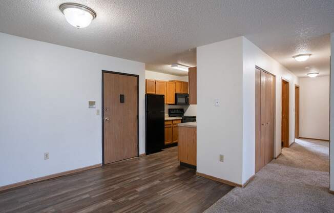 a dining room and kitchen with wood flooring and white walls. Fargo, ND  Prairie Park Apartments