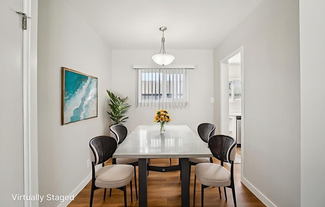A dining room with a table and chairs.