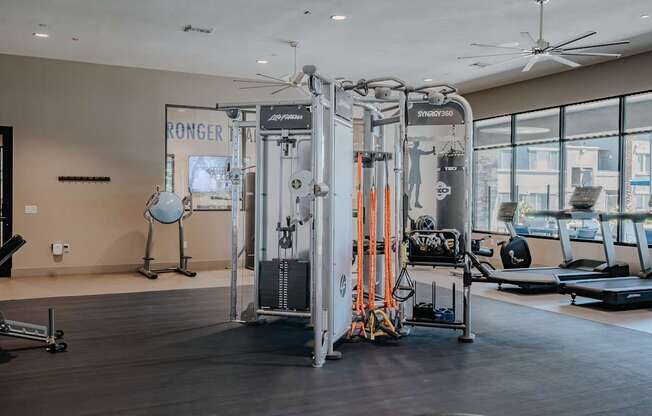 Multi-station strength training machine with kettlebells and ropes.