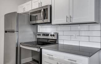 a kitchen with white cabinets and stainless steel appliances