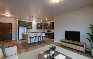 a living room with a kitchen and a tv in it. Fargo, ND Prairiewood Meadows Apartments