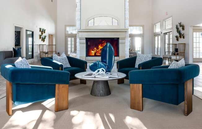 a living room with blue chairs and a fireplace