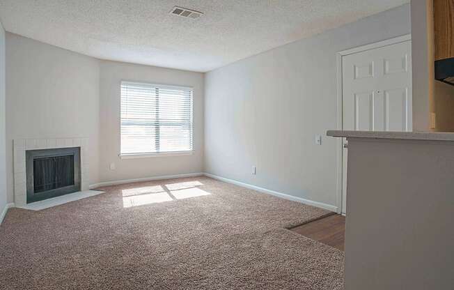 an empty living room with a fireplace and a door