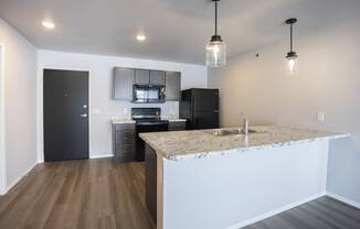 Modern open-concept kitchen and living area with black appliances.