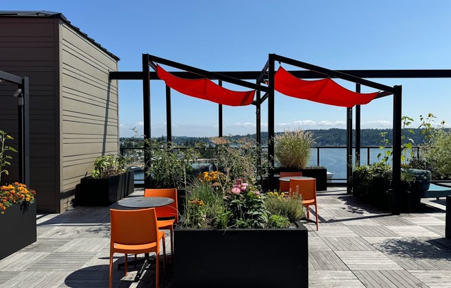 a rooftop terrace with orange chairs and tables at Spyglass Hill Apartments, Washington 98337
