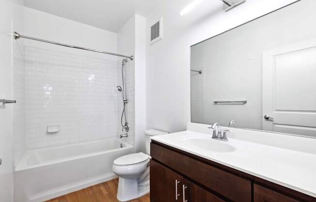 A white bathroom with a toilet, sink, and bathtub.