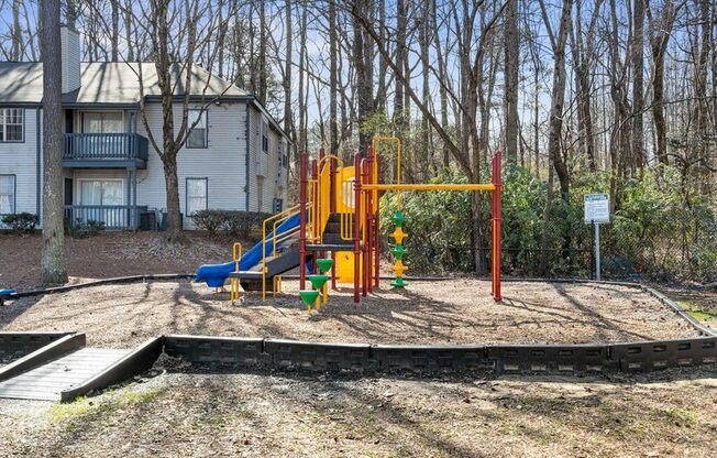 a playground with a swing set in front of a house