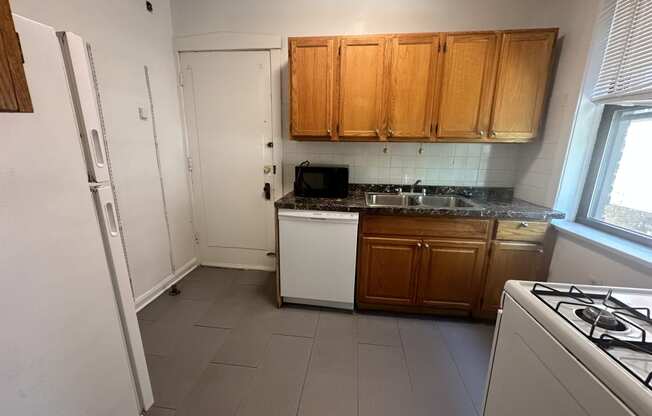 a kitchen with white appliances and wooden cabinets