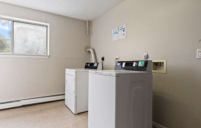 a laundry room with a washer and dryer and a window