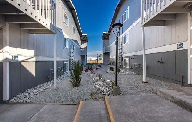Exterior view of manicured rock path between buildings at The Lakes Apartments, Moses Lake, WA.