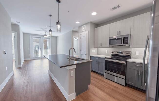 A modern kitchen with a large island and stainless steel appliances.