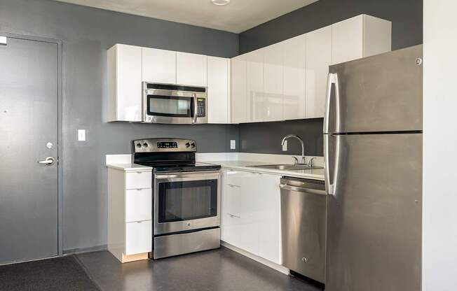 A modern kitchen with stainless steel appliances and white cabinets.
