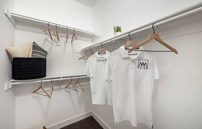 white shirts hanging on a rack in a dressing room at Paisley and Pointe Apartments, Nevada