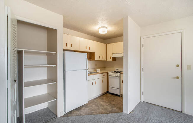 A kitchen with white appliances and cabinets.