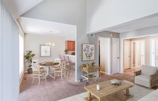 a living room and dining room with a table and chairs