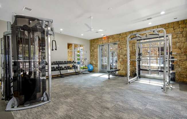 the home has a gym with exercise equipment and a stone wall