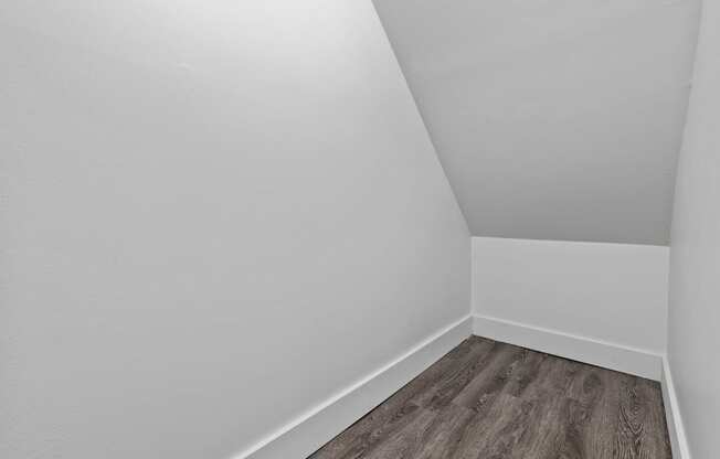 an empty room with a wooden floor and white walls