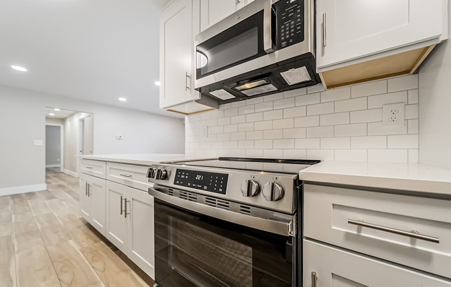A modern kitchen with a stainless steel oven and microwave.