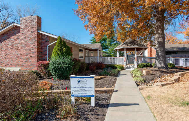 a sidewalk in front of a house with a sign on it