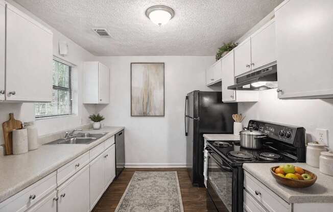 A kitchen with white cabinets and a black stove top oven.