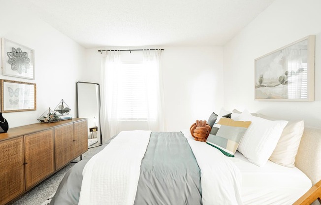 a bedroom with a large bed with white sheets and pillows
