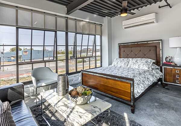 Steelcote Crossing bedroom area with concrete flooring and oversized windows at Steelcote Square, St. Louis, Missouri