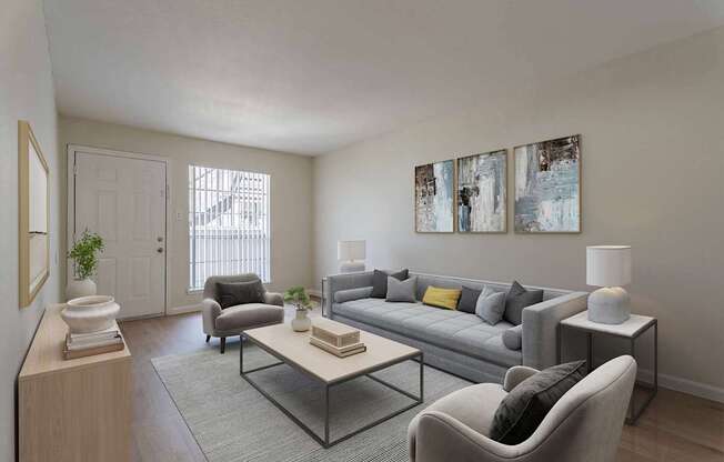 A living room with a grey couch, a grey armchair, a coffee table, a lamp, and two paintings on the wall.
